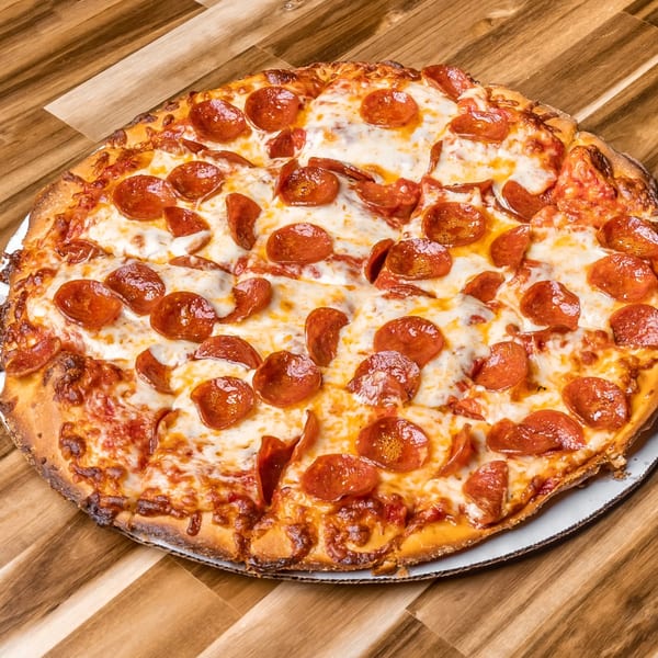 A whole pepperoni pizza from Slammers, sliced and ready to eat on a wooden table.